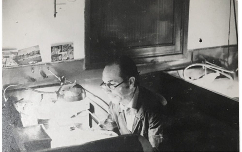 Person sitting at a desk and working on crafting jewelry