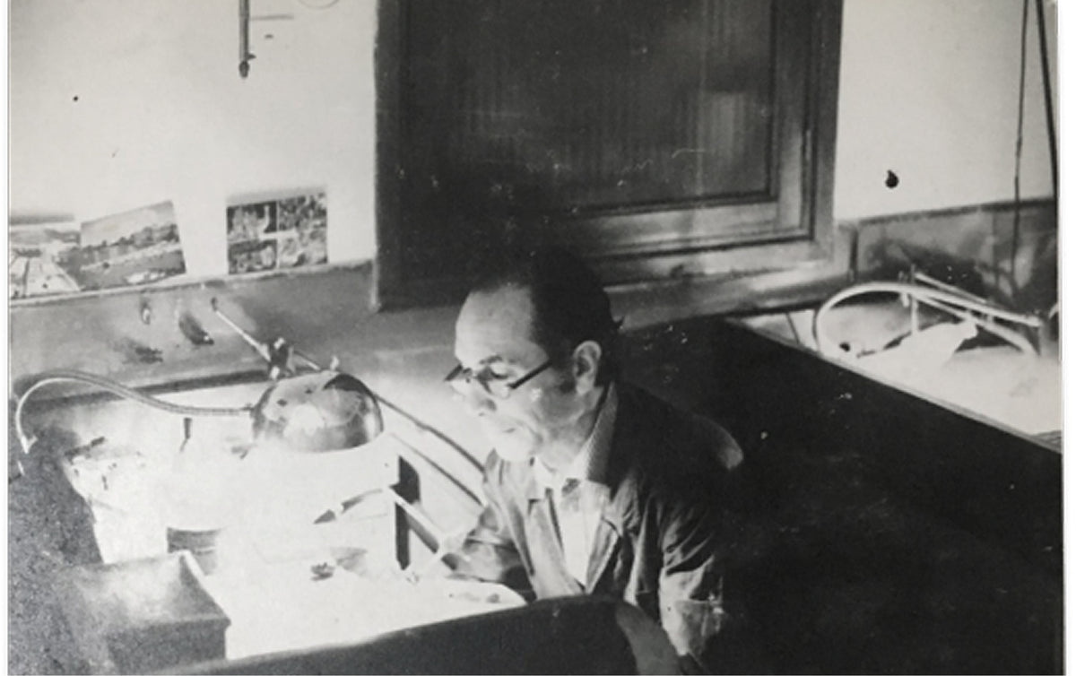 Person sitting at a desk and working on crafting jewelry