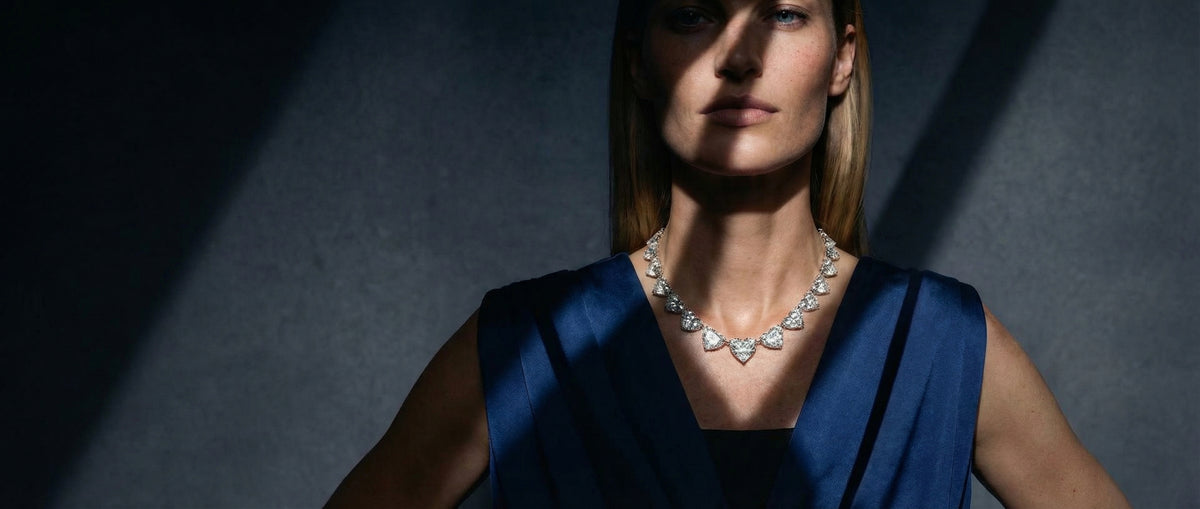 Woman wearing a diamond necklace against a dark background