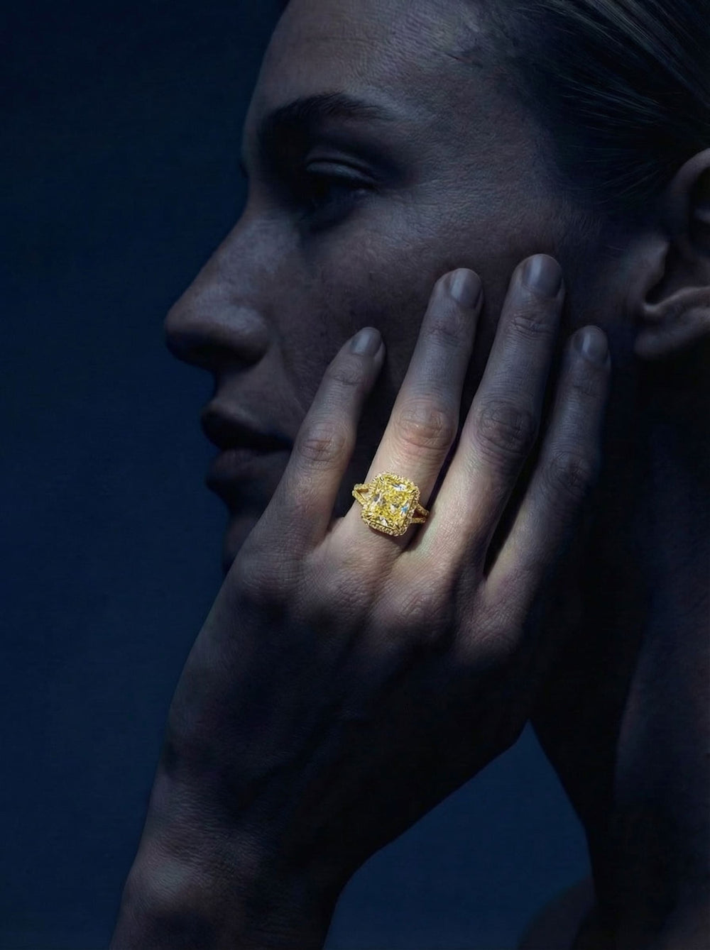 Close-up of a hand with a gold ring on a dark background